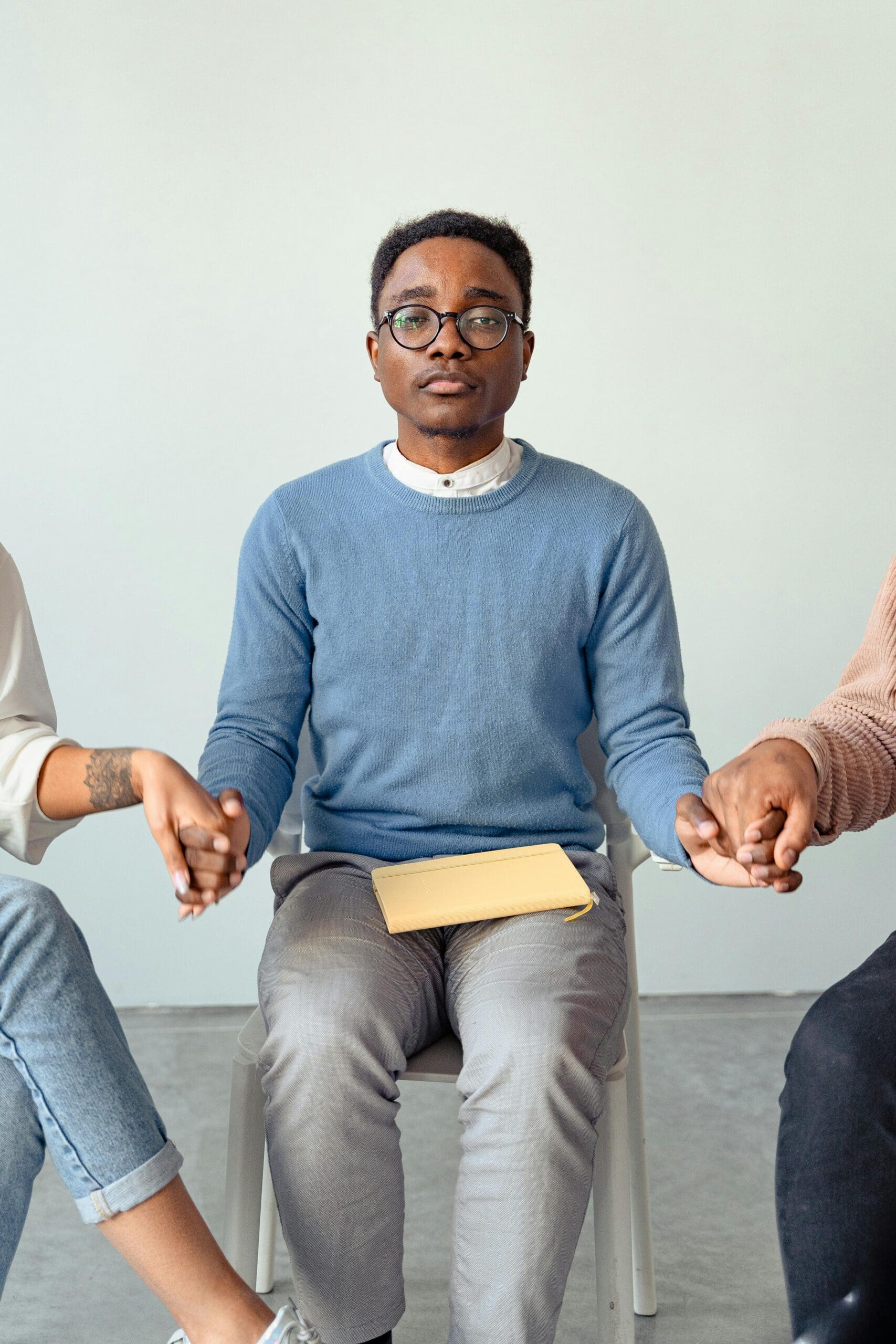 man sitting holding hands for support while looking at audience for connection