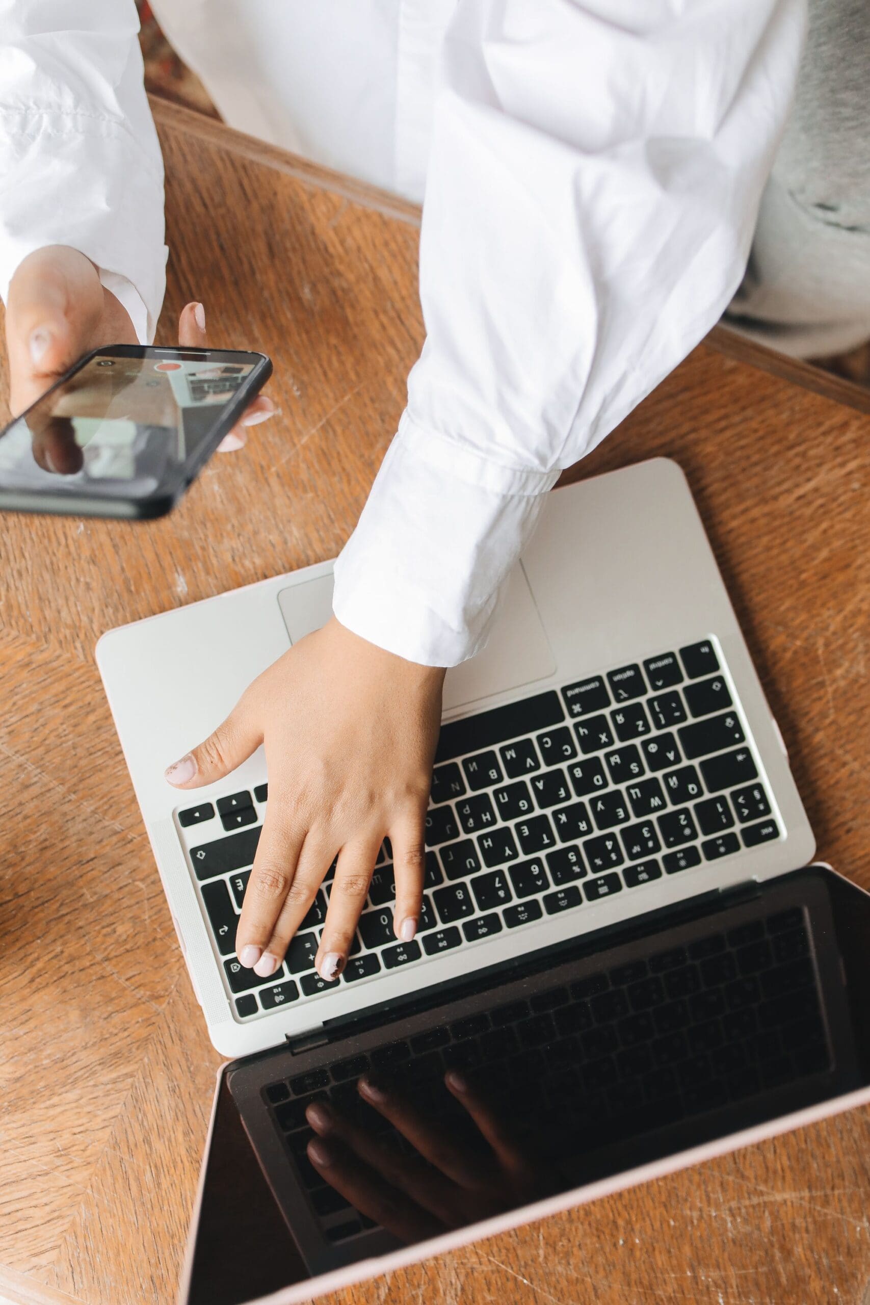 individual typing a HIPAA Compliant Email on their computer and mobile phone as a therapist